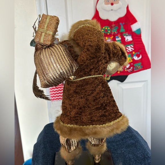 Golden velvet clad Santa holds greenery. - Picture 3 of 7